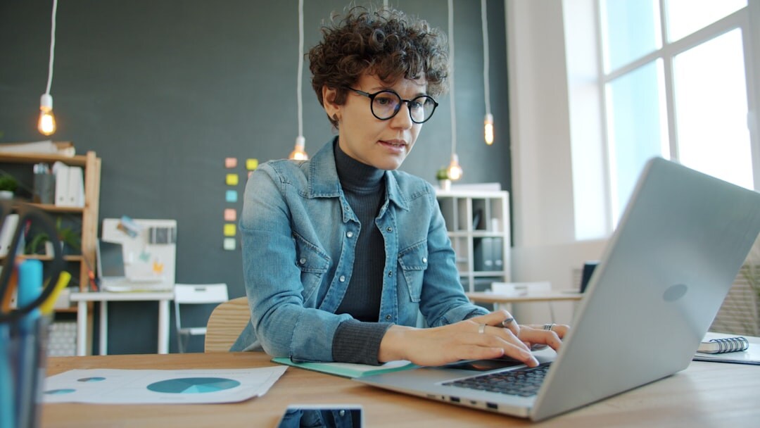 young adult creating budget on laptop